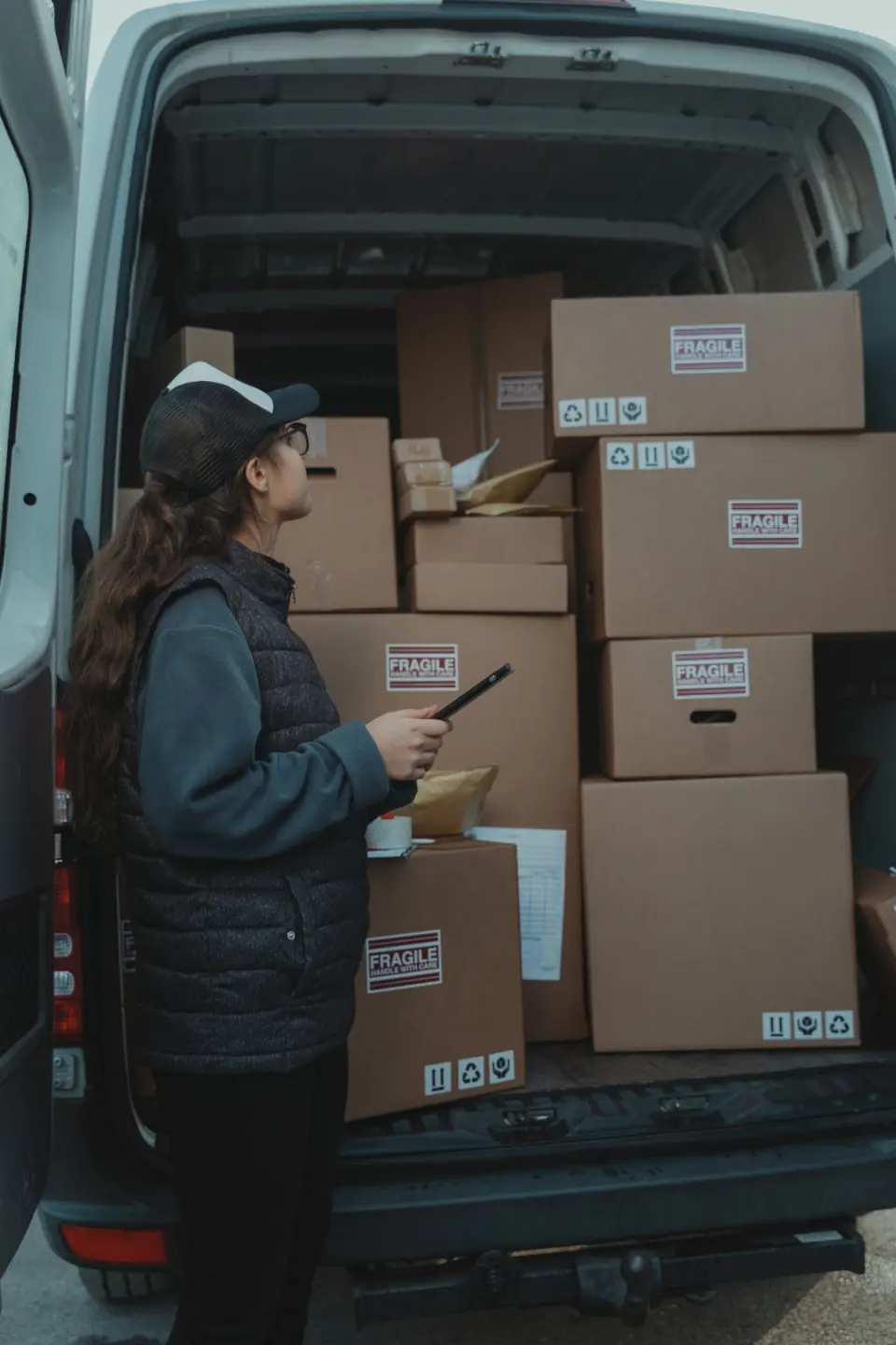 A depot supervisor checking a van's load against the manifest on a tablet